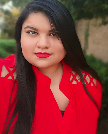 Photo of director Tara Moses, with long straight dark hair in a bright red top