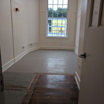Artist-in-Residence Studio Photo of artist studio with large window, white walls and wooden floor