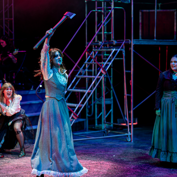 Scene from Lizzie, the Musical, taken by Jim Sabitus Character of Lizzie Borden wielding an axe in production of Lizzie, the Musical, taken by Jim Sabitus